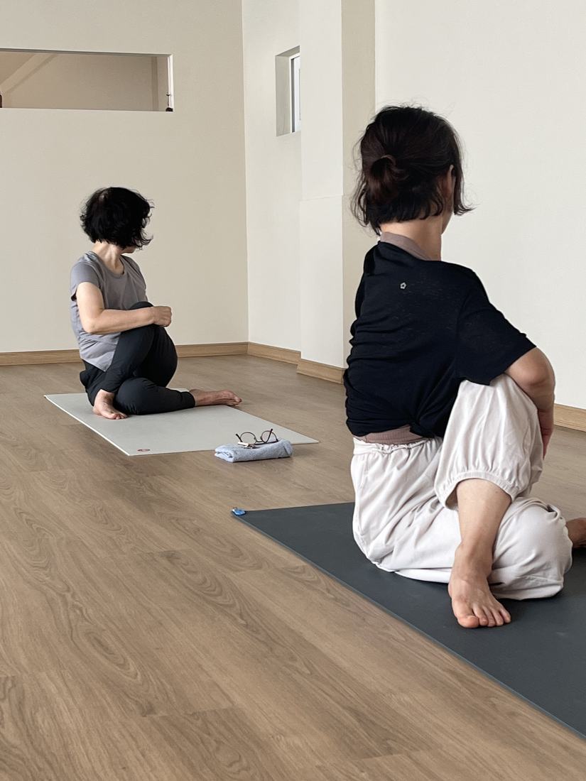두 수련생이 비틀기 자세를 하는 모습